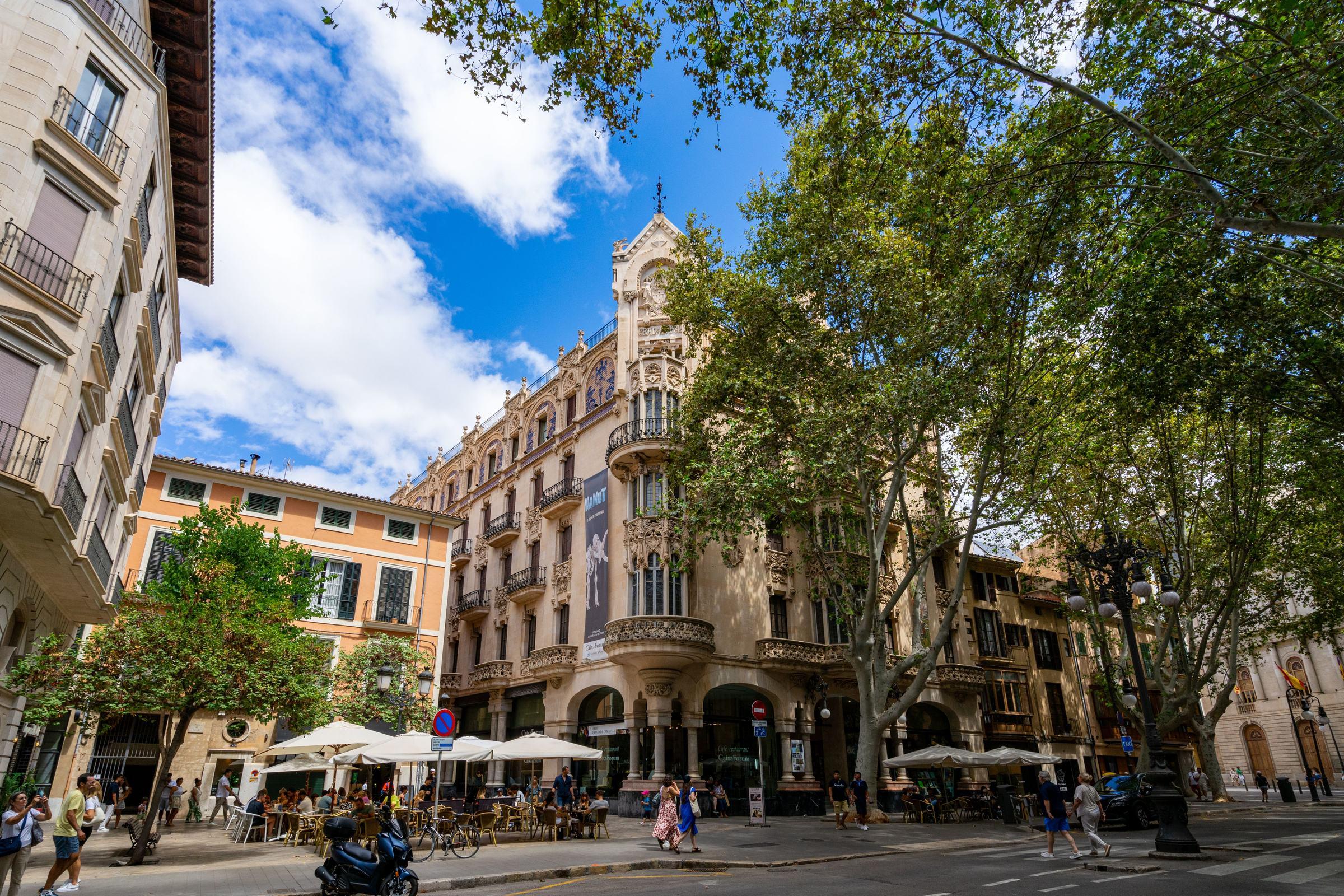 Plaza con cafés y un edificio modernista en Palma de Mallorca, España