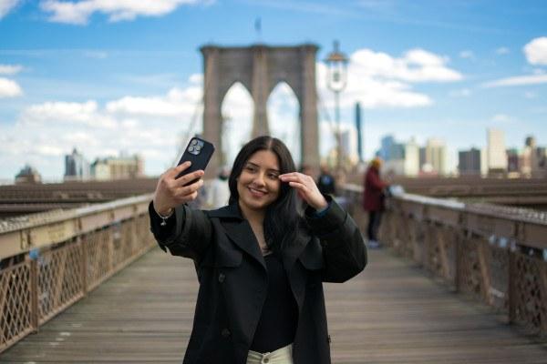 Viajera tomándose una foto en el puente de Brooklyn, en Nueva York