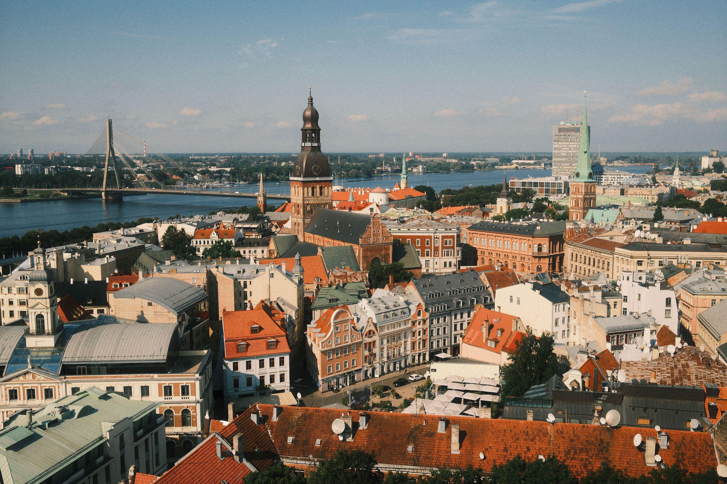 Vista de Riga, en Letonia, con sus tejados rojos, la torre de la catedral y el río Daugava